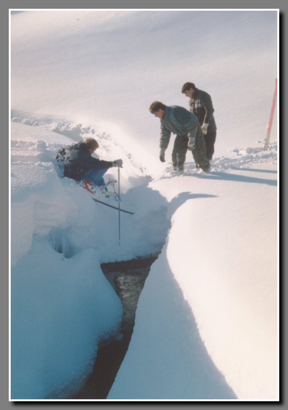 Sigurbjorn seems to be having some sorts of trouble with his skis,  while trying to cross the brook on a snow bridge. A careful observer will notice that there is a wooden bridge holding the snow. Judging from the people standing there it looks as if the snow is about 5 feet deep.